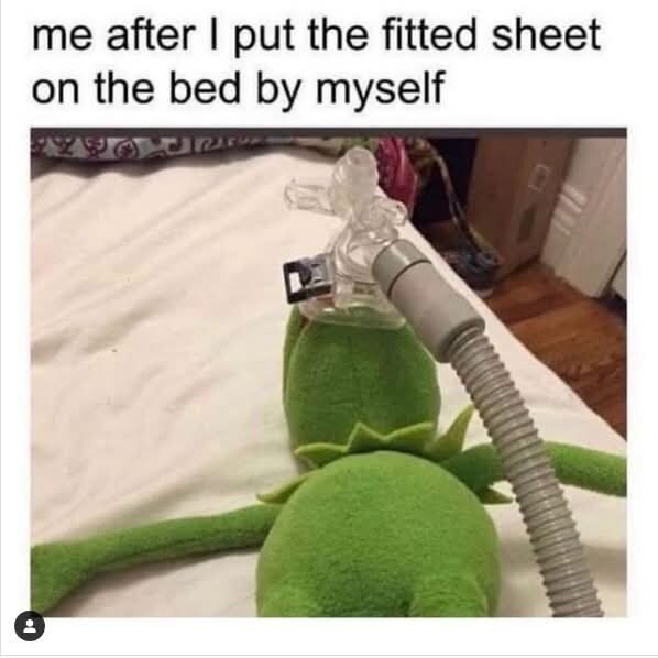 Grön docka ligger på en säng med en CPAP-mask över ansiktet, bredvid text som antyder trötthet efter att ha bäddat sängen ensam.