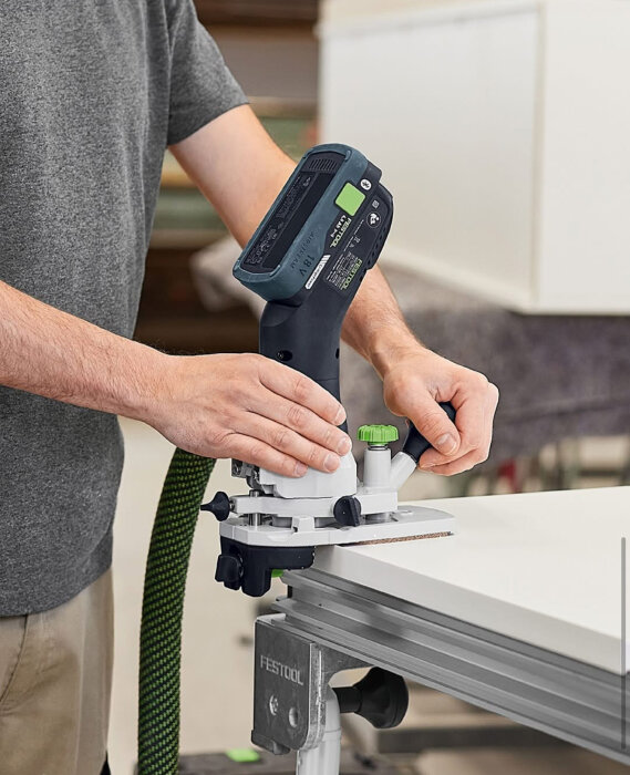 Person använder en plunge-såg från Festool för att såga i en bänkskiva.