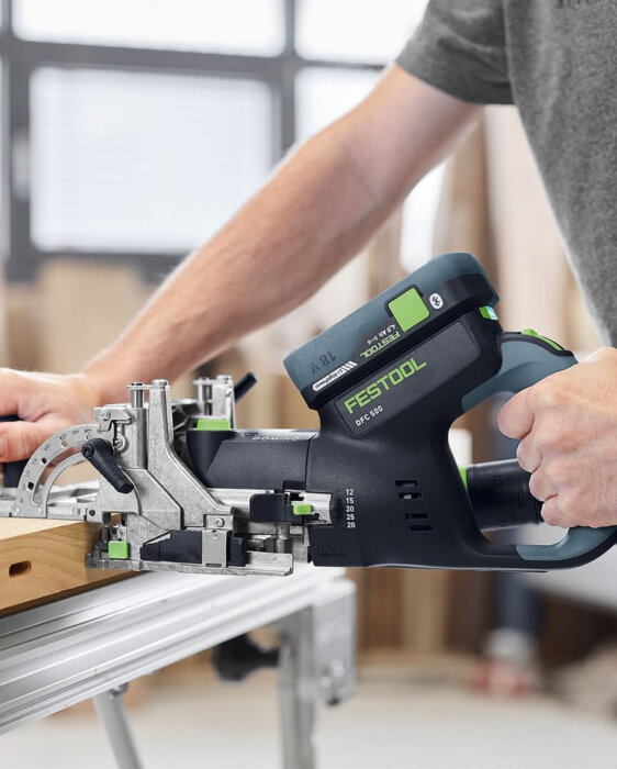 En person använder en Festool DFC 500 verktyg för att bearbeta en träbit.