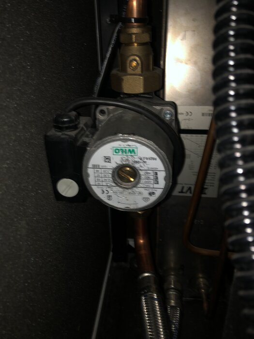 Värmebärarpump i ett jordvärmesystem, med koppar- och metallrör anslutna, märkt Wilo. Pump från 2005 med problem som beskrivs i inlägget.