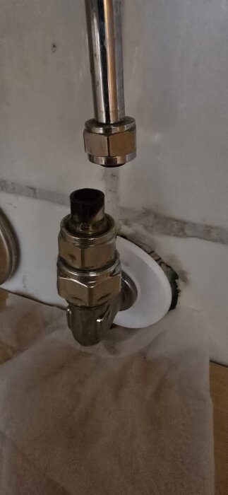 Övergångsnippel och klämring synliga i en isärskruvad anslutning på ett rörsystem.