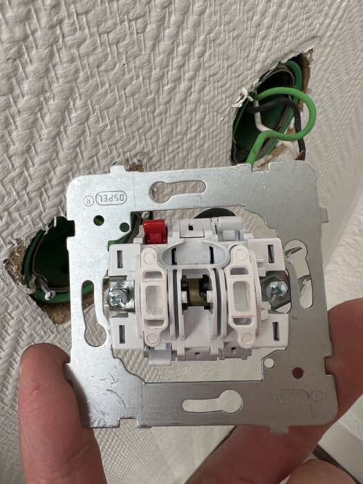 Vägguttag med tre kablar, grön, blå och svart, installerat i en vit vägg. Användaren önskar bekräftelse på korrekt installation.