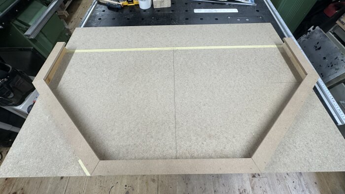 Råträstruktur för att testa modell av spelplan i oktagonform på en arbetsbänk.