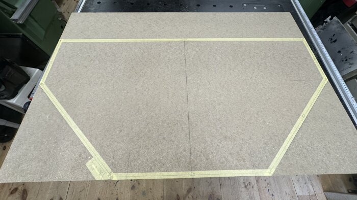 En skiva märkt med tejp i en oktagonform, förberedd för att tillverka en spelplan.