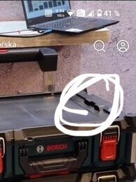 Inringat fäste på Bosch förvaringslåda, med laptop ovanpå en hylla i bakgrunden.