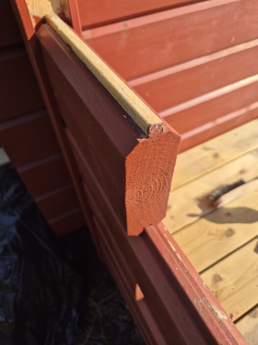 Rött halvtimmer virke används som staket runt en friggebods altan. Se trädäck och stående panelklädsel. Dimension: 130x45.