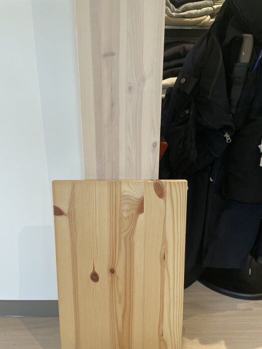 Behandlad och obehandlad furuskiva jämförda i ljus inomhusmiljö.