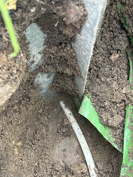 Mark med en vit kabel delvis skadad av ett stolpspjut.