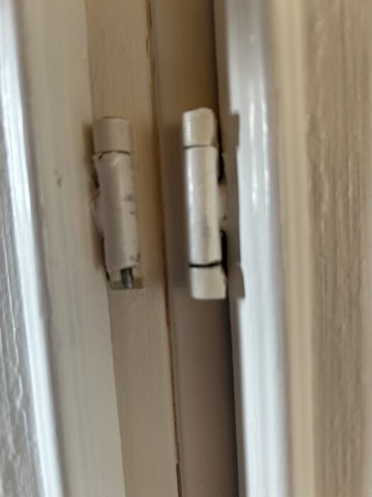 Gångjärn från 1960-70-tal på en garderobsdörr, visar slitage och behov av ersättning.