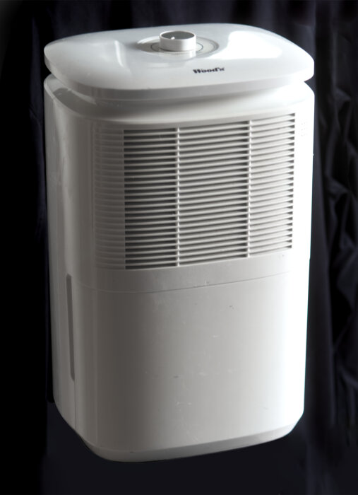 En avfuktare med vit plastdesign, frontgaller och toppenhet synlig. Modellen visar ventiler och öppningar för luftflöde.