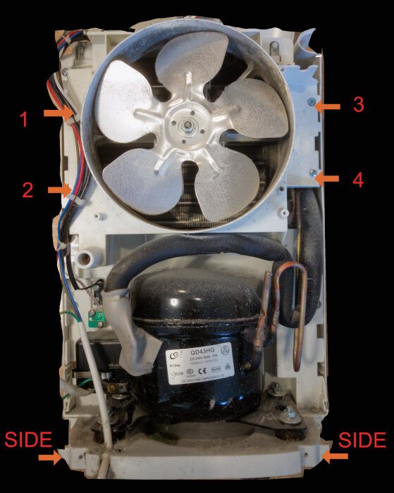 Inuti en avfuktare med synlig fläkt och kompressor. Kablar och kopplingar är markerade med pilar. Maskinen har demonterats för rengöring.