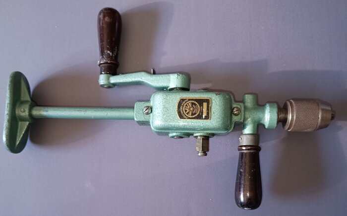 Handdriven borrmaskin med två utväxlingar från Eskilstuna mekaniska verkstad, med trähandtag och metallkropp.