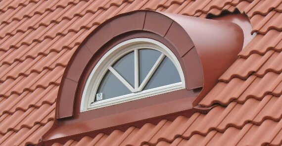 Bågformat takfönster i plåt, placerat på ett tegeltak.