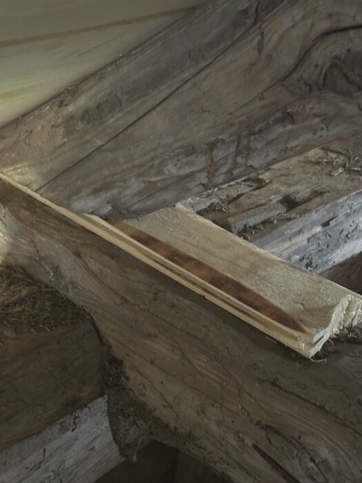 Takstol med monterad spont-bit i ett uthus under takomläggning, använt för att räta upp konstruktionen.