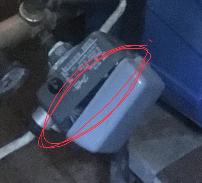 Tryckströmbrytare med locket delvis avskruvat, röd cirkel markerar locket. Risk för exponerade kontaktbleck i ett utrymme med vattentryck.