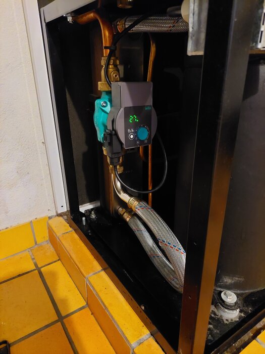 Vattenpump och ventiler med åtskilliga rör och anslutningar, del av ett VVS-system monterat med ny utrustning mot läckage.