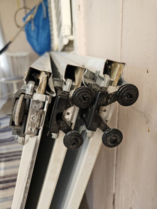 Närbild av spegelskjutdörrar med hjul av modell stanley 17-4264y-000, lutade mot en vägg inomhus.