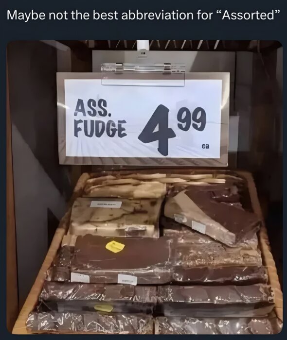 Prisskylt i butikshylla visar "ASS. FUDGE 4.99" med förpackningar av fudge under.