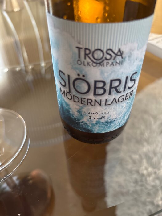 Flaska Trosa Sjöbris Modern Lager öl, 5,4 vol%, på ett bord.