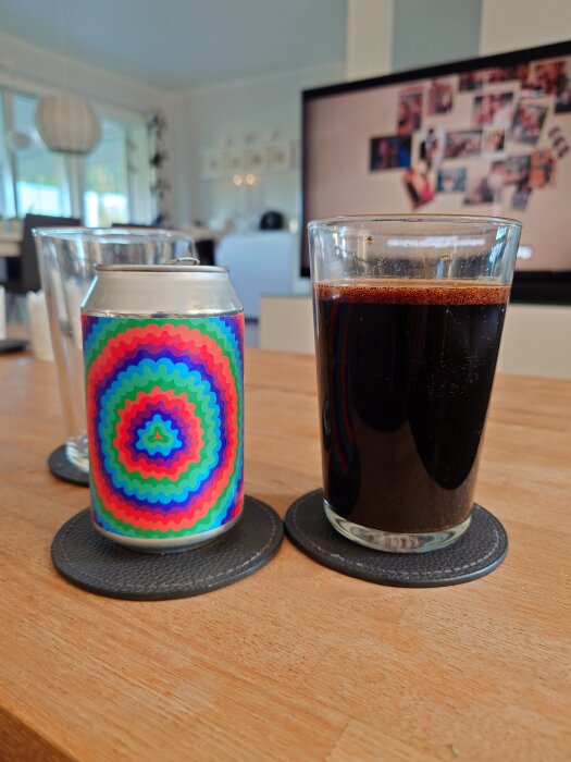 Burk med färgglatt mönster och ett glas mörk vätska på ett bord. I bakgrunden syns en tv och ett rum.