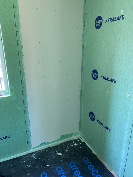 Delaminerad gipsskiva i duschhörn med bubblig Kerasafe-folie, exponerad gips, och skador från felaktigt lim.