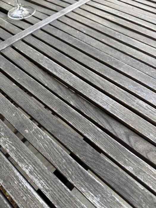 Skeva träplankor på ett IKEA Visingsö bord utomhus, fokus på ojämna ytor och struktur.