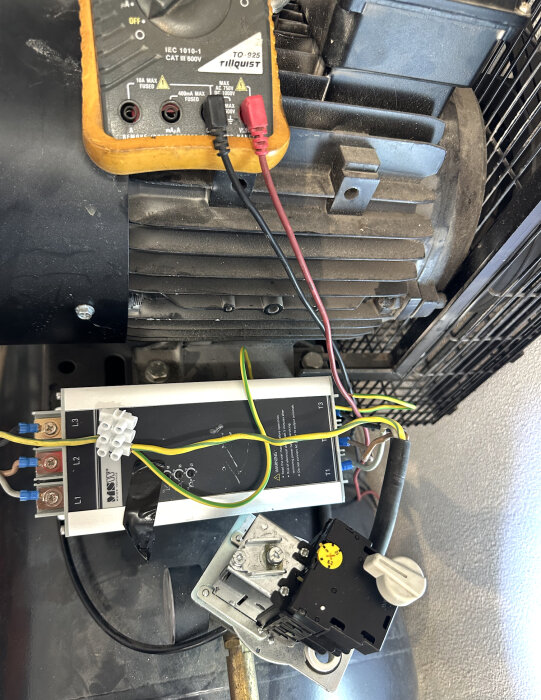 Multimeterkopplingar till en elektrisk motor med kablage och en mjukstartare, del av ett test för att lösa kopplingsproblem.