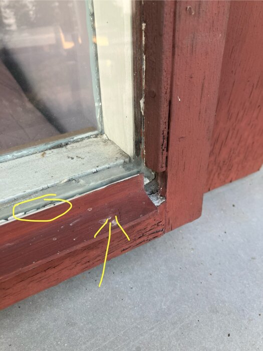 Gammalt pivotfönster med alulist i nederkant markerat med gul pil och eventuell kittning inringad. Fönstrets träram är sliten.