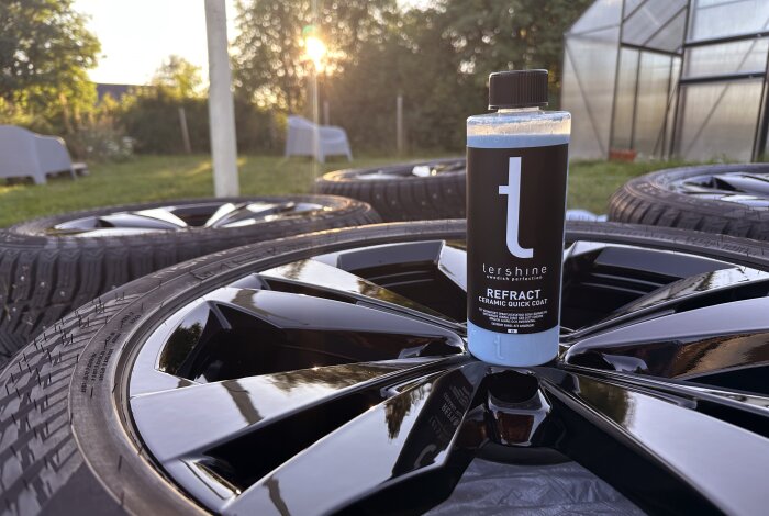 Tershine Refract Ceramic Quick Coat flaska står på blanka, nypolerade hjul i trädgårdsmiljö.
