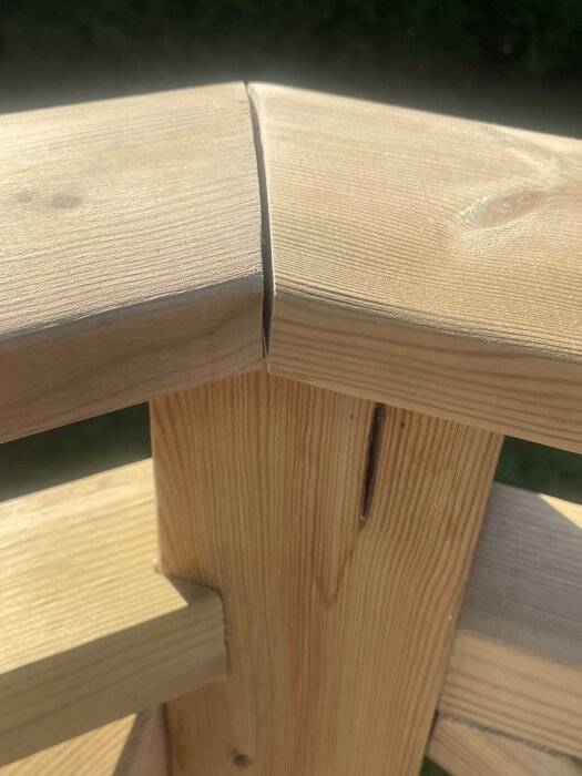 Skarv mellan två överliggare på en altan med träkonstruktion, söker förslag på hållbar lösning.