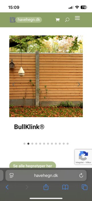 Trästaket sektion med vågräta plankor och betongstolpe, omgiven av höstlöv och grönska.