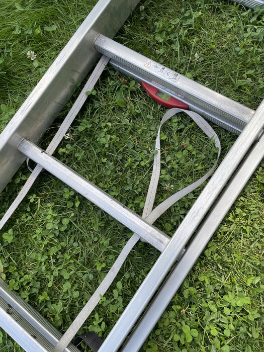 Hymerstege delvis utdragen på gräs, visar överlappande steg och röd plastmarkör.