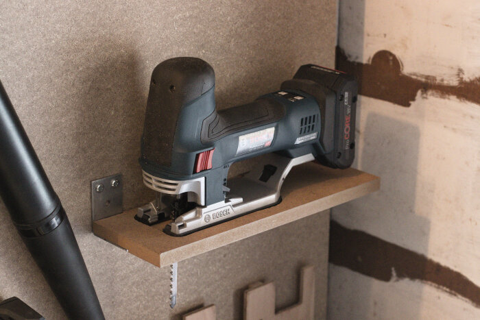 Sticksåg från Bosch placerad på en hylla av MDF-skiva fastsatt med vinkeljärn, del av ett byggprojekt i ett diskussionsforum om verktyg och maskiner.