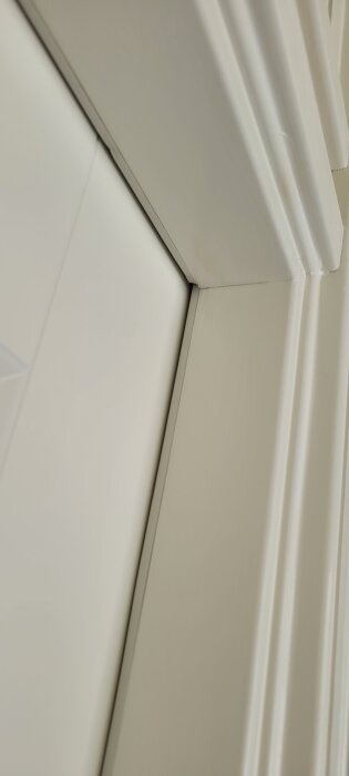 Skev vit toalettdörr med glipor upptill och nertill, korrekt placerad vid låset.