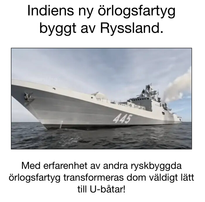 Grått örlogsfartyg med nummer 445 seglar på havet under blå himmel med moln.