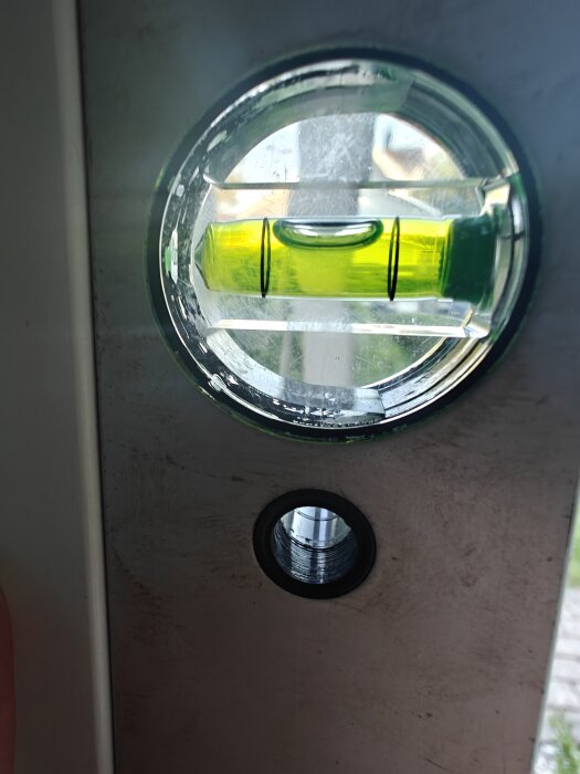 Vattenpass lutande åt sidan, visar snett monterat fönster i närbild.