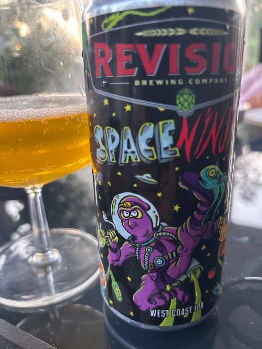 Ett ölglas och en burk med design av en rymdninja från Revision Brewing Company, beskriven som en West Coast IPA.