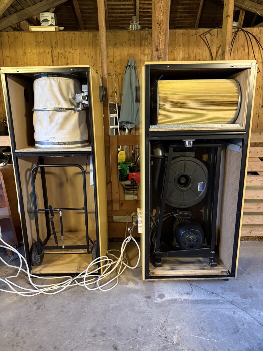 Industrikvalitet Åss spånsug modell 1100 i träverkstad med två stora enheter, en med filter och en med fläktenhet, omgivna av träpaneler.