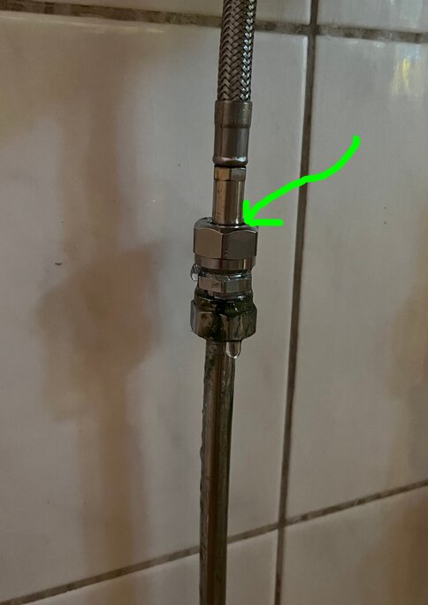 Vattenrör med koppling i badrum, pil markerar möjligt mellanrum.