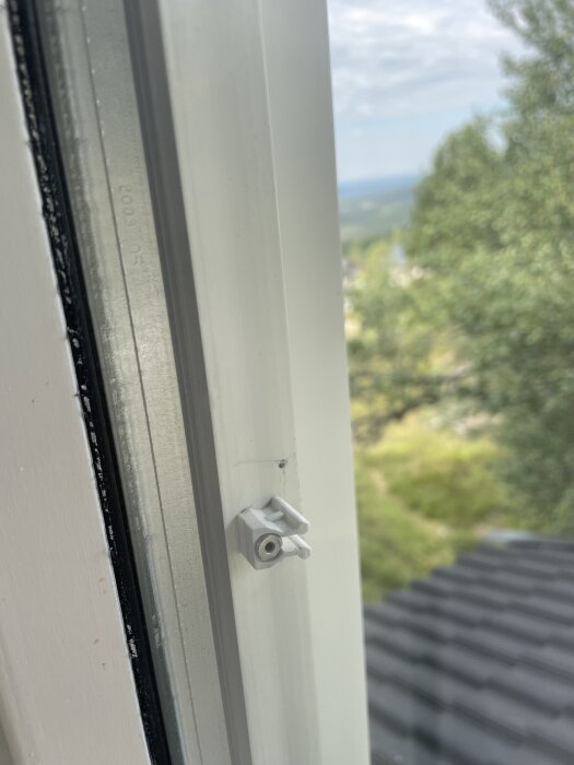 Träfönster med trasigt spröjsfäste och Emmaboda Climatlit glas, utomhusmiljö i bakgrunden.