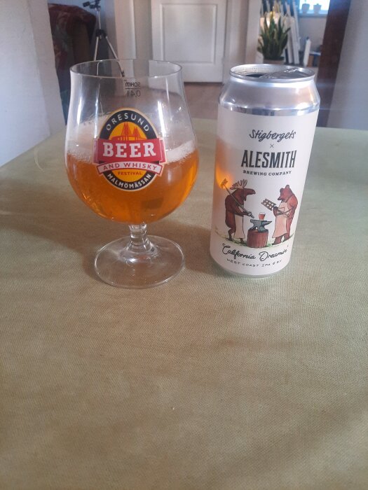 Ett glas med öl från Öresund Beer and Whisky Festival och en burk Stigbergets IPA på ett bord.