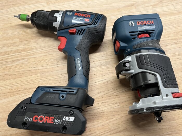 Verktygsbild som visar en Bosch skruvdragare och en kantfräs placerade på ett träbord.