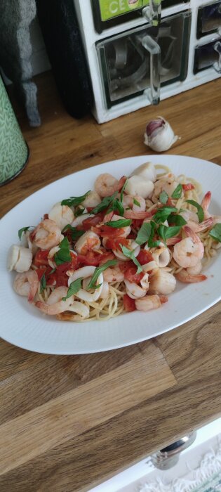 Skaldjurspasta på tallrik med räkor, bläckfisk och färska örter.