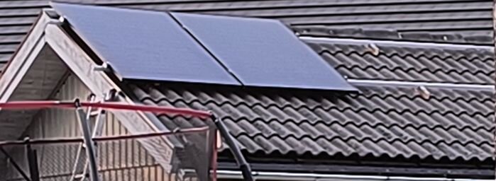 Solpaneler monterade på ett tegeltak med hjälp av regler av tryckimpregnerat virke, som visas med takpannorna runt omkring.