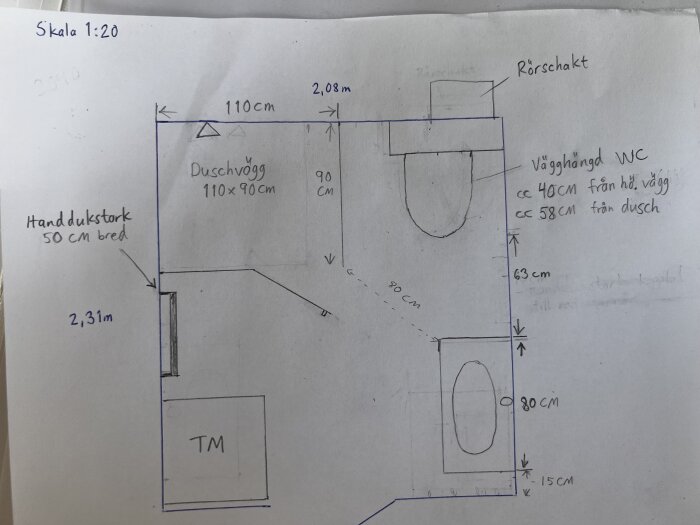 Ritning av badrum med duschvägg, väggmonterad WC, handdukstork, och plats för tvättmaskin. Mått och placeringar anges i cm.