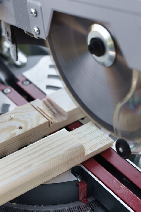 Kap- och gersåg som skär träbit för skohyllans konsoler.