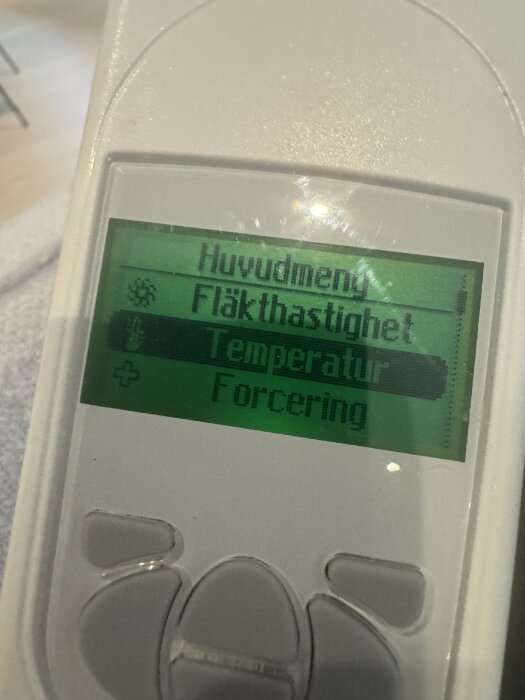 Fjärrkontroll med skärm som visar huvudmeny, fläkthastighet, temperatur inställd på 16 grader och forcering.