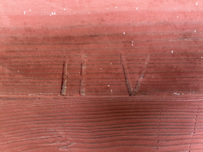 Röd trävägg med inskriptionerna "HV".