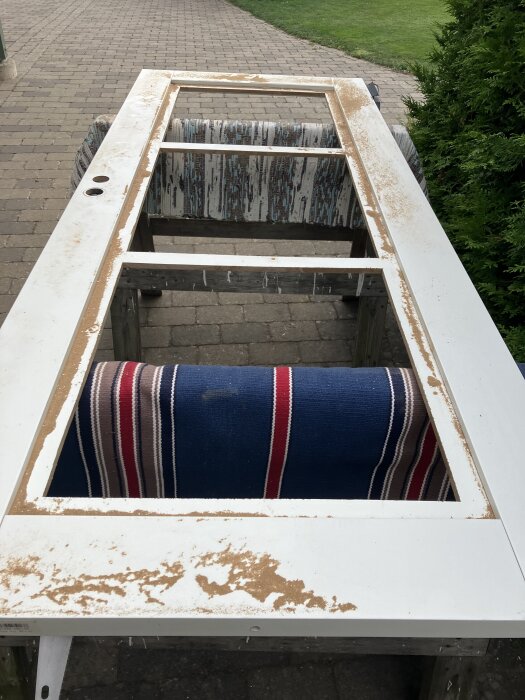 Pärlspontskiva med öppningar för fönster, limmad och spikad på masonitremsor, står på en bock, förberedelse för montering.