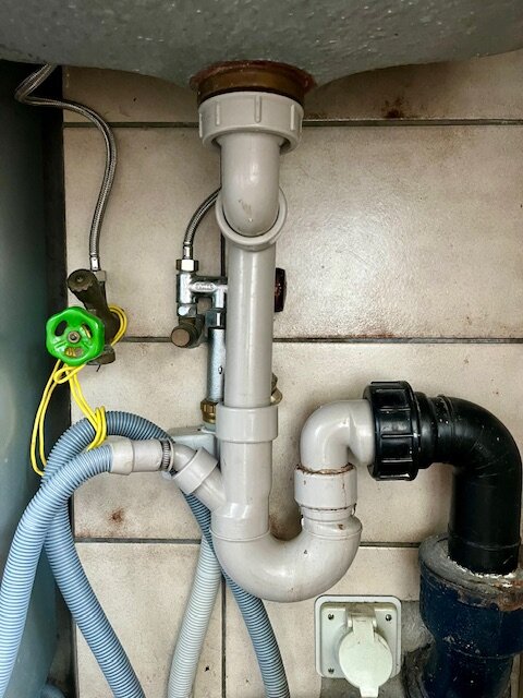 Läckande och dåligt installerat vattenlås i kök, med rörkopplingar som är fippliga och svårhanterade, behov av rejäla kopplingar och låsningar.
